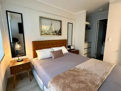 a bedroom with a large bed and two windows at Departamento Osma in Lima