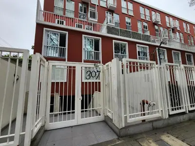 a white fence in front of a red building at Departamento Osma in Lima