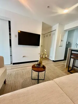 a living room with a couch and a tv on a wall at Great New Studio in Barranco in Lima