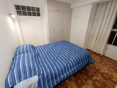 a bedroom with a bed with a blue striped comforter at Apartamento en Cusco IV in Cusco