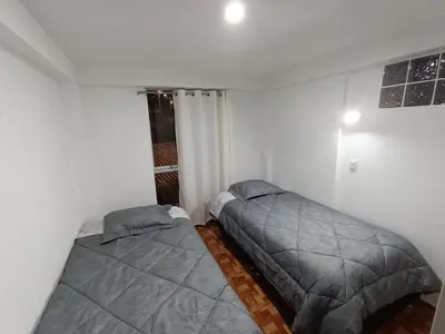 a bedroom with two beds and a window at Apartamento en Cusco IV in Cusco