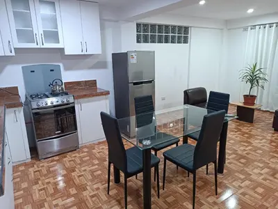 a kitchen with a table and chairs and appliances at Apartamento en Cusco IV in Cusco