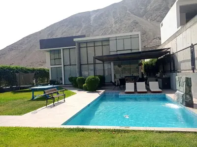 a house with a swimming pool in front of a mountain at Maya House Cieneguilla in Cieneguilla
