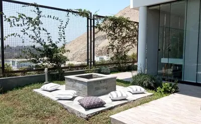 a stone bench with pillows on it next to a building at Maya House Cieneguilla in Cieneguilla