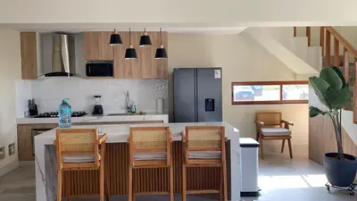 a kitchen with a table with chairs and a refrigerator at Casa Campo-Playa Sand in My Shoes in Chincha