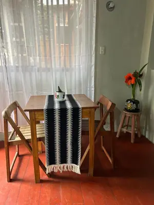 a wooden table with two blankets on it next to a window at Valentino Vent in Cusco
