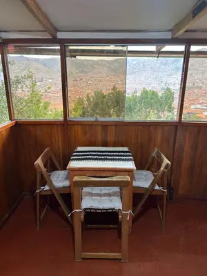 a table and two chairs in a room with a view at Valentino Vent in Cusco