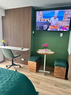 a room with a tv on a green wall with a table at Bertolotto, divino minidepa smartv wifi y amoblado in Lima