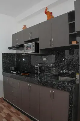 a kitchen with a black counter top with a sink at Valle Sagrado Mágico in Urubamba