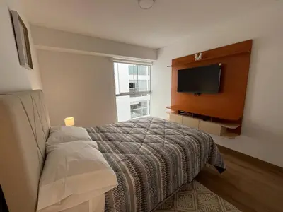 a bedroom with a bed and a flat screen tv at Entire apartment minutes from Miraflores in Lima