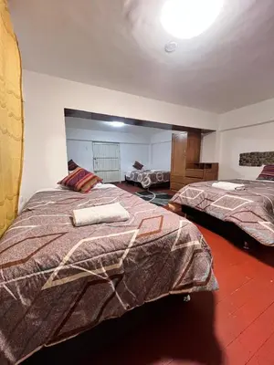 a bedroom with two beds in a room at SkyGuest Cusco San Cristobal in Cusco