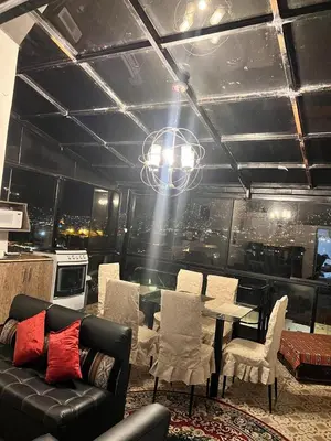 a living room with a couch and a table and chairs at SkyGuest Cusco San Cristobal in Cusco