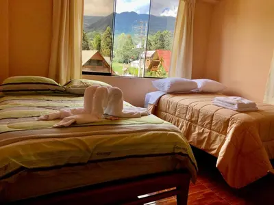 two beds in a room with a window at Echevarria Oxapampa in Oxapampa