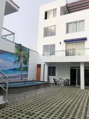 a white house with a patio and a swimming pool at Bravos Hospedaje Punta Negra in Punta Negra