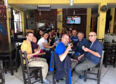 a group of people sitting at a table in a restaurant at Hospedaje Mayo Huacachina in Ica