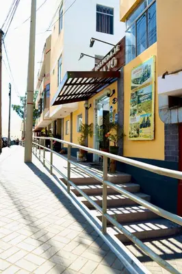 a sidewalk in front of a building with a railing at Hospedaje Mayo Huacachina in Ica