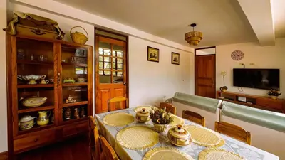 a dining room with a table and a tv at Fundo Venegas & Montoya in Jauja