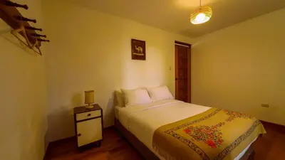 a small bedroom with a bed and a night stand at Fundo Venegas & Montoya in Jauja