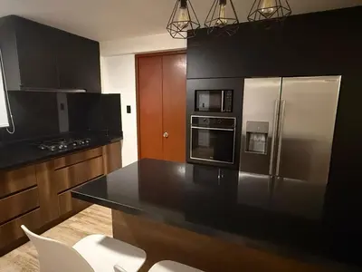 a kitchen with black counters and stainless steel appliances at Welcoming apartment in Lima