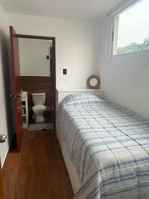 a bedroom with a bed and a toilet and a window at Welcoming apartment in Lima