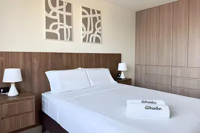 a bedroom with a white bed and two lamps at The 28 Residence Miraflores in Lima
