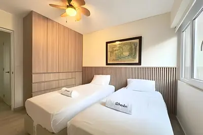 two beds in a room with a ceiling fan at The 28 Residence Miraflores in Lima