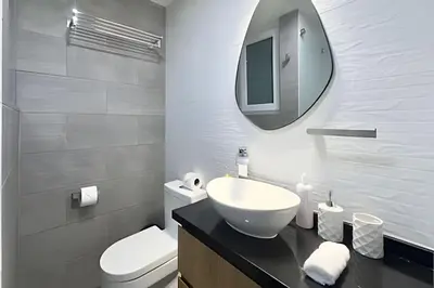 a bathroom with a sink and a toilet and a mirror at The 28 Residence Miraflores in Lima