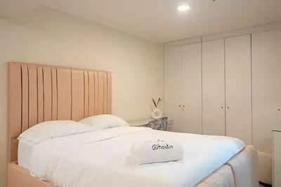 a bedroom with a large white bed with aania bag on it at The Urban Loft in San Miguel in Lima