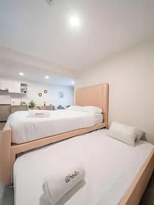 two twin beds in a room with a kitchen at The Urban Loft in San Miguel in Lima