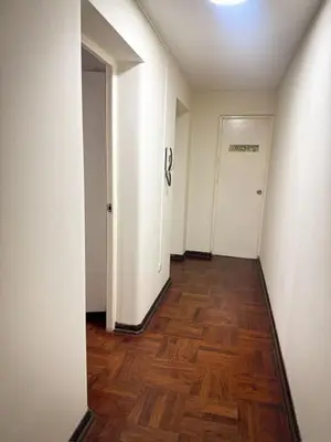 an empty hallway with a wooden floor and white walls at Miraflores, habitación en apartamento compartido in Lima