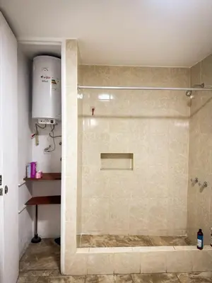 a shower with a glass door in a bathroom at Miraflores, habitación en apartamento compartido in Lima