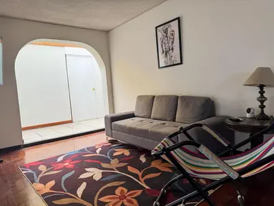 a living room with a couch and a table at Miraflores, habitación Triple en apartamento compartido in Lima