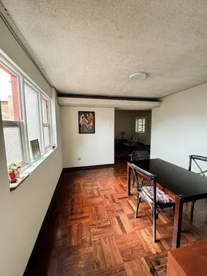 an empty living room with a wooden floor and windows at Miraflores, habitación Triple en apartamento compartido in Lima