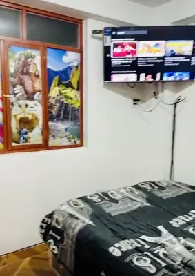 a bedroom with a bed and a tv on the wall at Tampumachay in Cusco