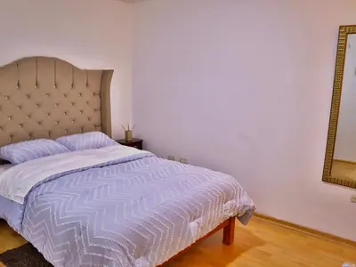 a bedroom with a bed and a mirror at Lindo depa cerca a huacachina in Ica