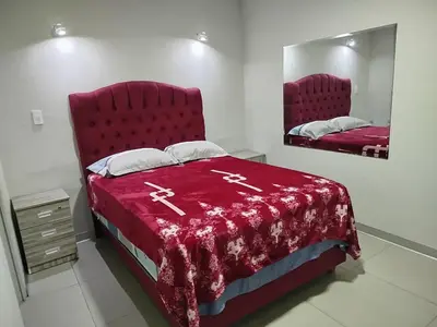 a bedroom with a red bed and a mirror at Hostal San Ignacio Monterrico in Lima
