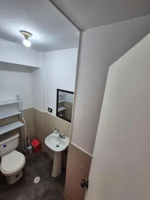 a bathroom with a white toilet and a sink at Luna Room in Lima