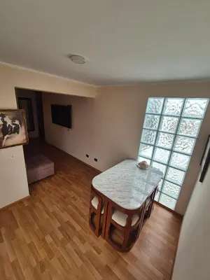 a living room with a table and a large window at Luna Room in Lima