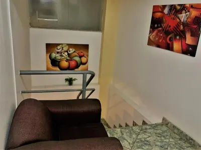 a living room with a chair and a painting on the wall at Departamento turístico Rosaelena b&b 9 personas in Cusco