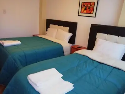two beds sitting next to each other in a room at Departamento turístico Rosaelena b&b 9 personas in Cusco