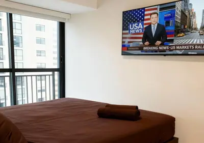 a bedroom with a television hanging on the wall at E 24h Urban Comfort 1BR 302 in Lima