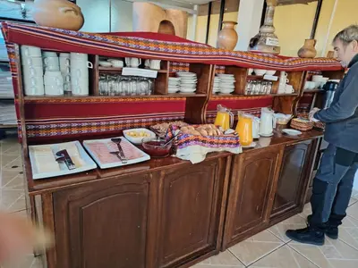 a man standing in front of a counter with food at Inkas Hotel Cusco in Cusco