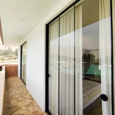 a hallway with glass doors with a bed in it at Casa de Campo Privada en Cieneguilla con Piscina y Cine in Cieneguilla