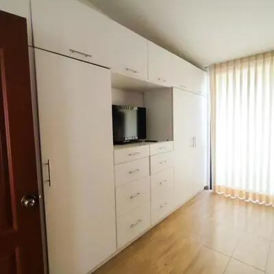 a living room with white cabinets and a tv at Casa de Campo Privada en Cieneguilla con Piscina y Cine in Cieneguilla