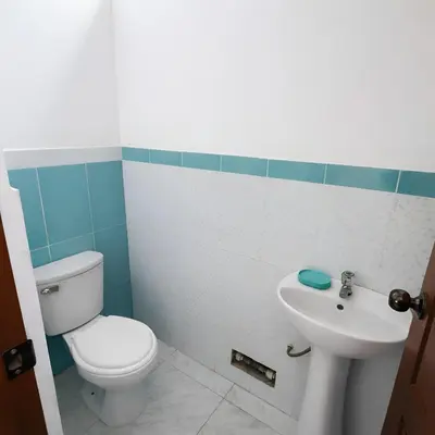 a bathroom with a toilet and a sink at Casa de Campo Privada en Cieneguilla con Piscina y Cine in Cieneguilla