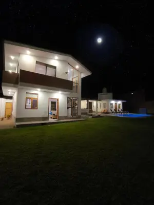 a house at night with the moon in the sky at Casa de Campo Privada en Cieneguilla con Piscina y Cine in Cieneguilla