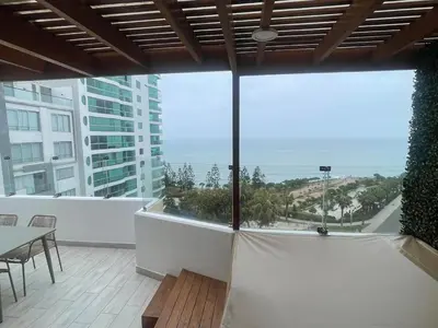 a balcony with a table and a view of the ocean at Penthouse con Vista al Mar in Lima