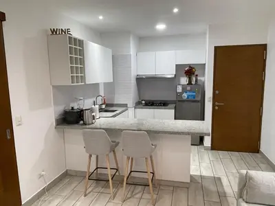 a kitchen with white cabinets and two stools in it at Penthouse con Vista al Mar in Lima