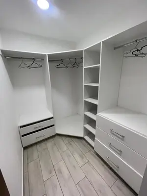 a walk in closet with white cabinets and a wooden floor at Penthouse con Vista al Mar in Lima