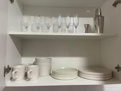 a white shelf with wine glasses and plates on it at Penthouse con Vista al Mar in Lima